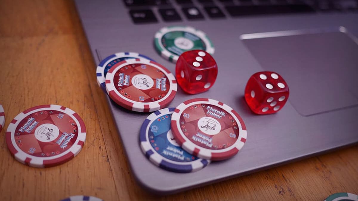 Laptop on Table with Casino Chips Spread Out