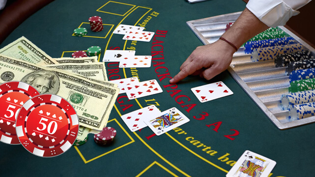 Dealer Grabbing Blackjack Cards, Poker Chips and Money Spread Out
